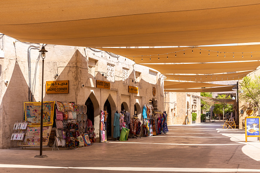 Dubai, UAE, 27.09.2021. Al Fahidi Historical District stone street with traditional craft souvenir shops and sunshades above, Deira, Dubai.
