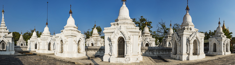 Kuthodaw Pagoda contains the worlds biggest book. There are 729 white stupas with caves with a marble slab inside - page with buddhist inscription. Panoramic photo. Mandalay, Myanmar