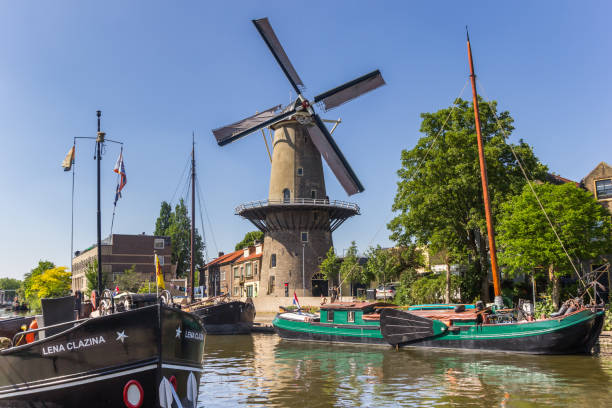 Historic windmill De Roode Leeuw in the harbor of Gouda Historic windmill De Roode Leeuw in the harbor of Gouda, Netherlands gouda south holland stock pictures, royalty-free photos & images