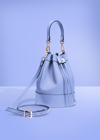 Fotografía de moda, bolso de cubo de diseñador de color azul sobre un fondo azul pastel con trazado de recorte photo