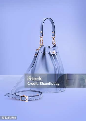 istock Fashion photography, blue color designer bucket bag on a pastel blue background with clipping path 1362513781