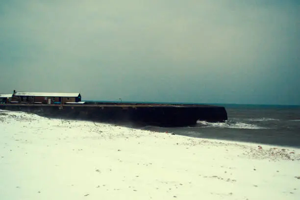 Snowcovered beach and the iconic Cobb in the background at Lyme regis in Dorset.