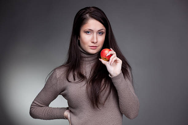 istock Beautiful girl with red apple on grey background 136251525