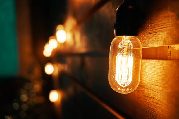 istock Antique incandescent Edison type bulb on wooden wall. 1362518629