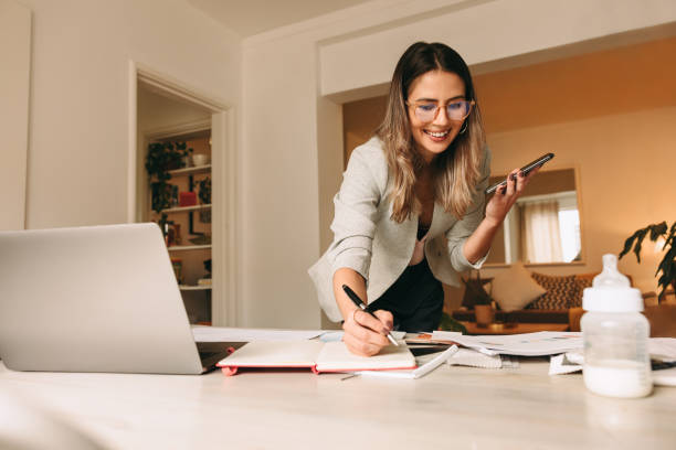 Happy interior designer speaking over the phone in her home office