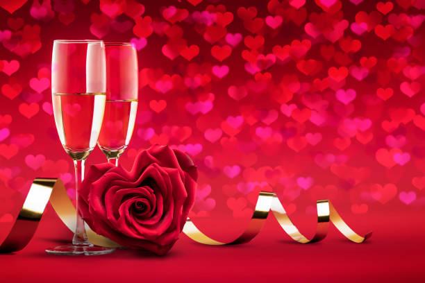 a rose in the shape of a heart, two glasses of champagne wine, a Valentine's day or wedding card romantic concept of the red color of love stock photo