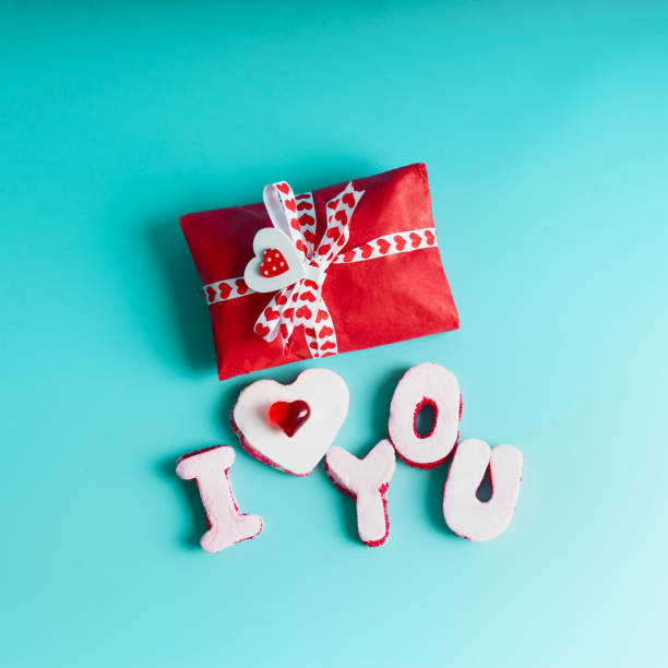 istock Valentines day gift box wrapping in red paper with heart and text made with marshmallow letters love you 1362519917