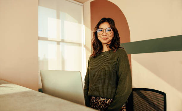 cheerful receptionist standing at the front desk - átrio imagens e fotografias de stock