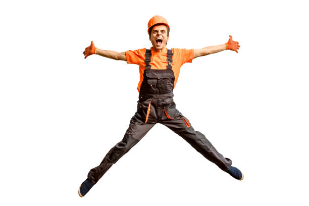 istock Young happy laughing caucasian man builder construction worker in a safety helmet is jumping in front of the roller door lifting gates 1362522377