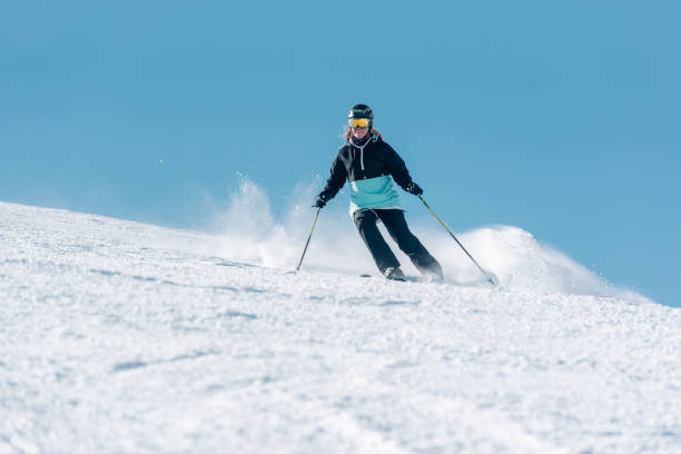 Woman skiing in the Pyrenees at the Grandvalira ski resort in Andorra in Covid19 time Pas de la Casa, Andorra: January 3, 2022: Woman skiing in the Pyrenees at the Grandvalira ski resort in Andorra in Covid19 time andorra photos stock pictures, royalty-free photos & images