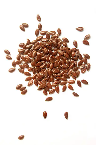 Photo of Brown flax seeds on a white background
