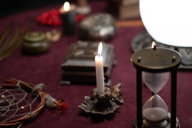 istock Table with objects for astrology. Burning candle book hourglass. 1362527696