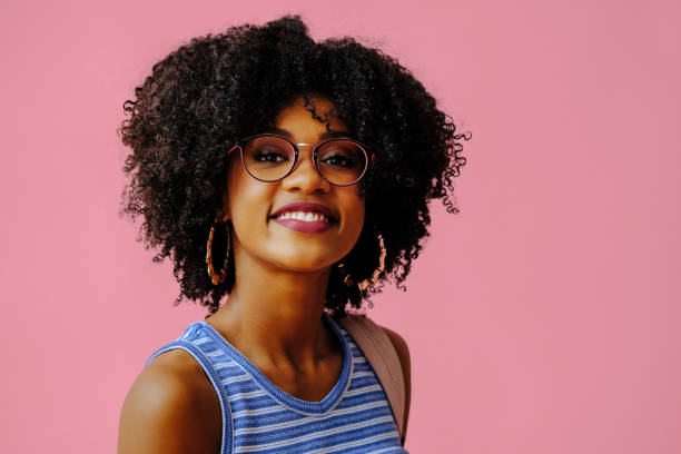 istock beautiful young female student in eyeglasses posing on pink background 1362530383