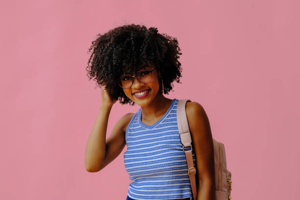istock beautiful young female student in eyeglasses posing on pink background 1362530412