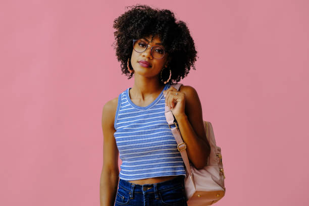 istock beautiful young female student in eyeglasses posing on pink background 1362530414