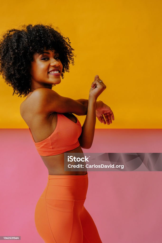 young fit woman in sportswear stretching and smiling at camera Exercising Stock Photo