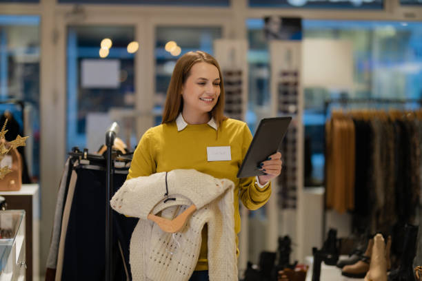 istock Woman using a digital tablet and sorting clothes in the store 1362539685