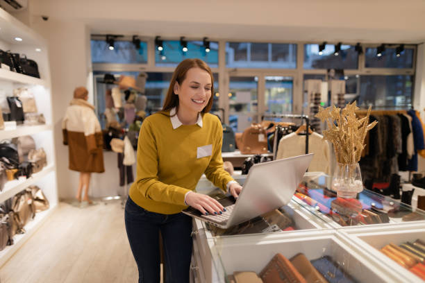 istock Young woman working in the clothing store using a laptop 1362540107