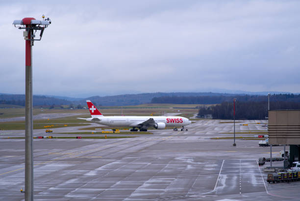 aéroport suisse zürich kloten avec fond de ciel nuageux. - runway airport sky wet photos et images de collection