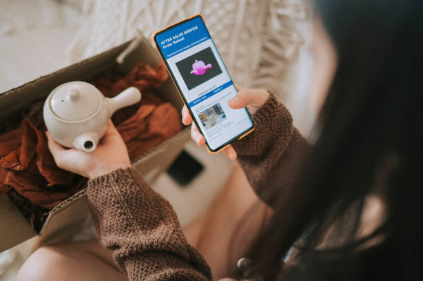 unhappy asian chinese woman complaining using mobile app on received different colour teapot from online shopping a living room