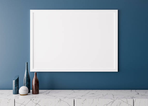 istock Empty white picture frame on blue wall in modern living room. Mock up interior in minimalist style. Free space, copy space for your picture. Marble console and vases. 3D rendering. Close up view. 1362542691