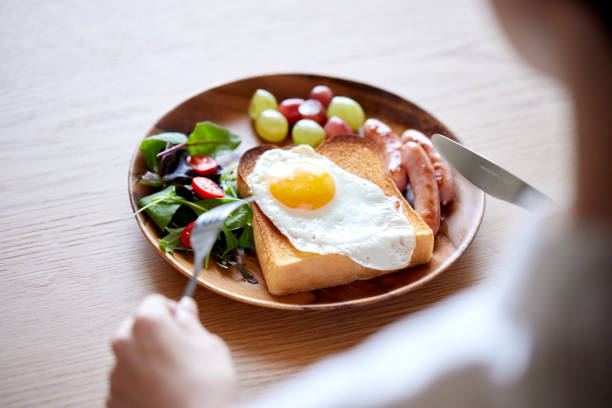 istock Hands of a woman eating breakfast 1362544004