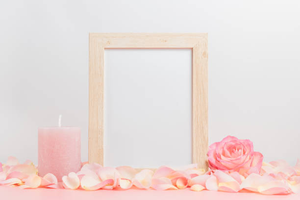 istock Empty photo frame with pink rose, petals and pink candle, photo frame mockup 1362544865