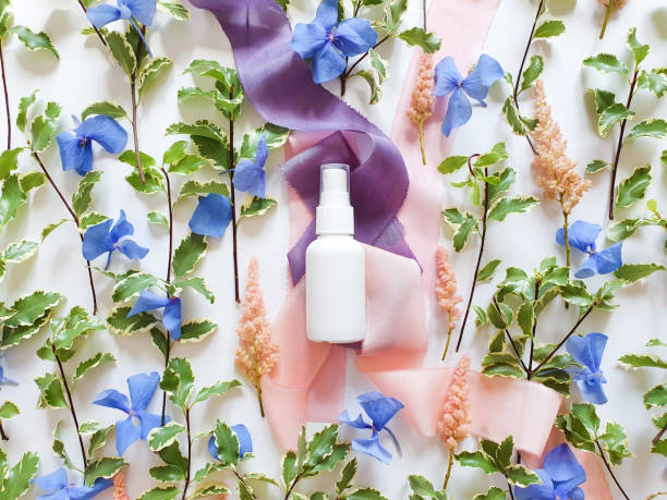 mockup of unbranded white plastic spray bottle, blue and pink flowers and silk ribbons on white table. bottle for branding and label. natural organic spa cosmetics and liquid antimicrobial spray. - liquid soap blue plastic textile imagens e fotografias de stock