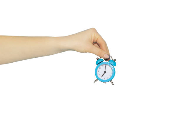 istock alarm clock in hand on white background, hand over or discard alarm clock 1362548187