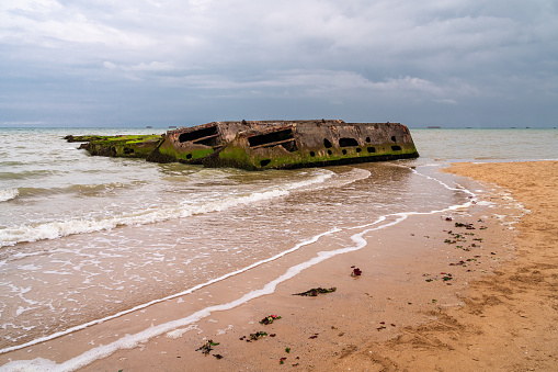 Remains of military artificial port from the world war and landing of allies in Arromanches, Normandy, France