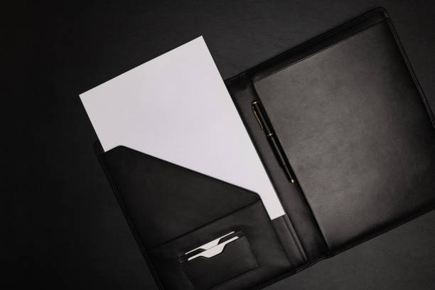 白い白い白い紙のシートが付いている黒い革のフォルダ - leather folder ストックフォトと画像