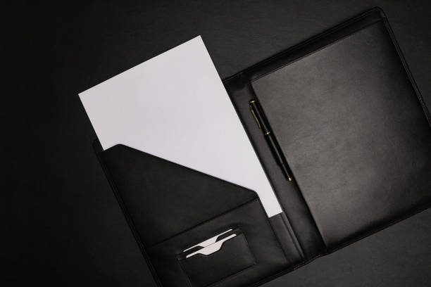 pasta de couro preto com folha de papel branco em branco - leather folder - fotografias e filmes do acervo