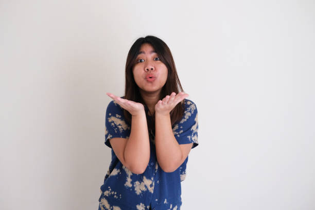 Young Asian women giving kiss gesture. Isolated white background Young Asian women giving kiss gesture. Isolated white background latar belakang stock pictures, royalty-free photos & images