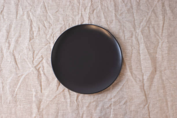 istock Dark colored circle shaped ceramic plate on isolated background, food mockup 1362558247