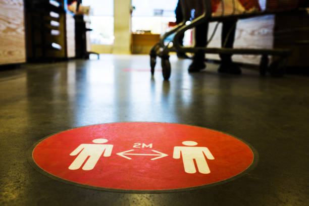 letrero de círculo rojo en el piso del supermercado que instruye a las personas a mantener una distancia de 2 metros entre sí - shopping mall supermarket store sign fotografías e imágenes de stock