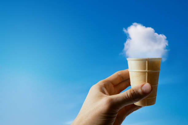 istock cloud ice cream. hand with waffle cup against blue sky. copy space 1362563490