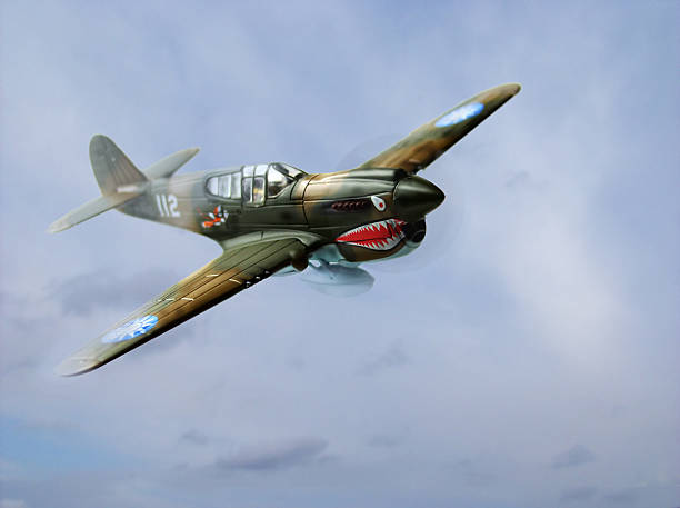 P40E Warhawk A World War 2 era P40E Warkawk flies out of the clouds. Compilation photo. toy airplane stock pictures, royalty-free photos & images