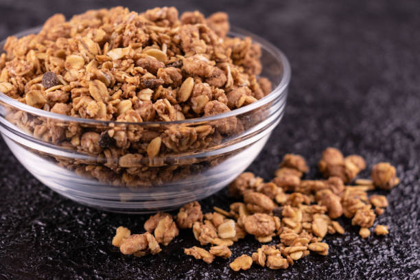 Healthy homemade muesli in a glass bowl on a black background. Close-up. Healthy homemade muesli in a glass bowl on a black background. Close-up. Granola stock pictures, royalty-free photos & images