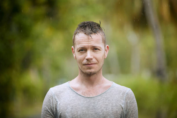 portrait og young man in heavy rain - rain drenched men wet imagens e fotografias de stock