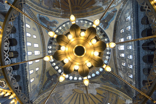Upwards view of Hagia Sophia Ayasofya large chandelier in the middle of the mosque under the grand dome. Constantinople Constantine byzantine empire ottoman empire Fatih conquest islam and christianity museum mosque