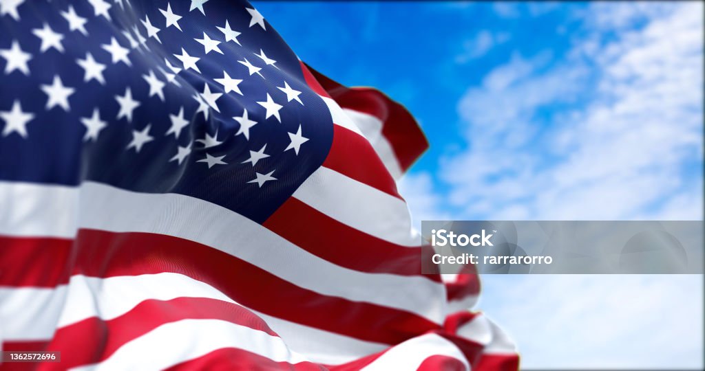 The national flag of the United States of America waving in the wind The national flag of the United States of America waving in the wind on a clear day. The flag has become a powerful symbol of Americanism American Flag Stock Photo