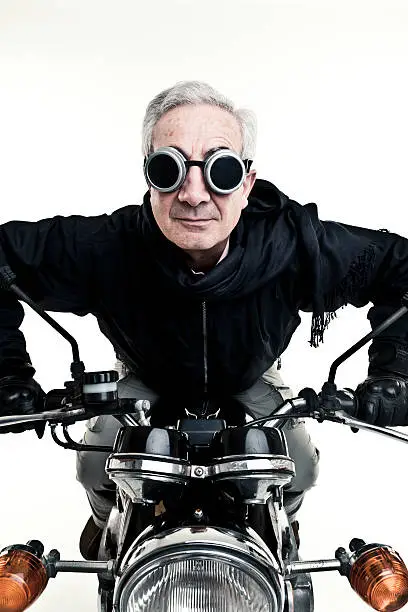 ironic and funny old man drive his old style motorcycle dressing protective glasses