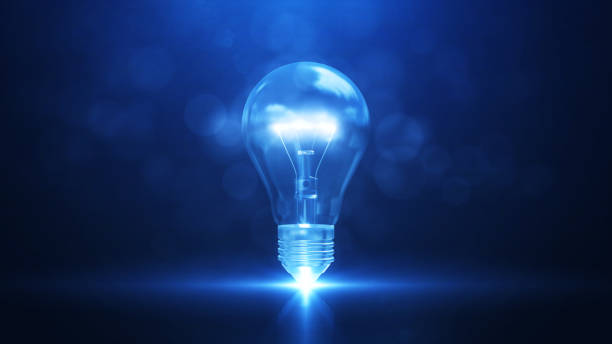 Creativity and new ideas. There is an electric bulb in the middle with bright white light. against a dark blue background. stock photo