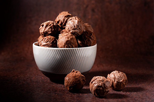 Chocolate Truffles in a bowl photographed on a brown background
