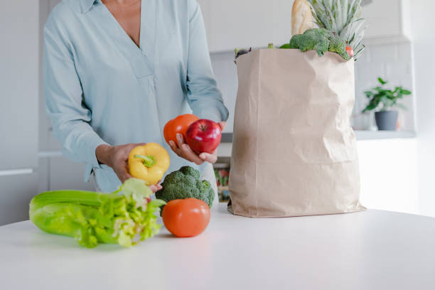 istock Woman's hands unpacking bag full of groceries 1362581930