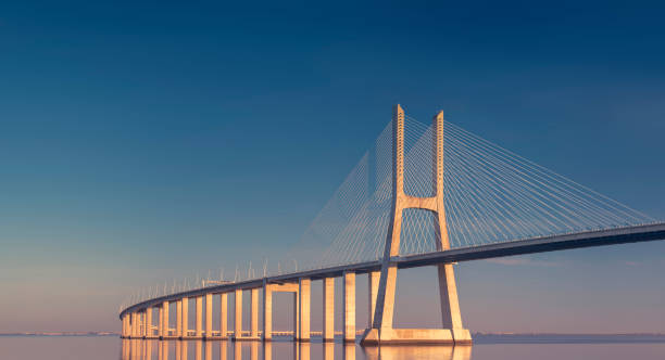 リスボン、ポルトガルの日没時のヴァスコ・ダ・ガマ橋 - 橋 ストックフォトと画像