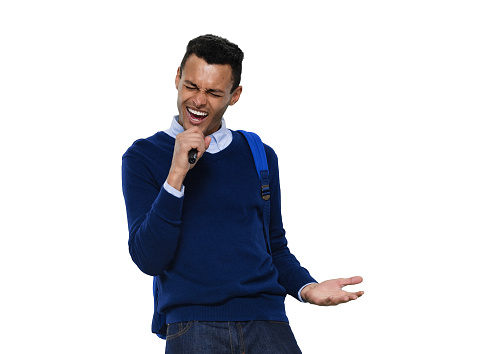 Portrait of aged 20-29 years old with black hair generation z young male singer dancing in front of white background wearing backpack who is singing and holding microphone