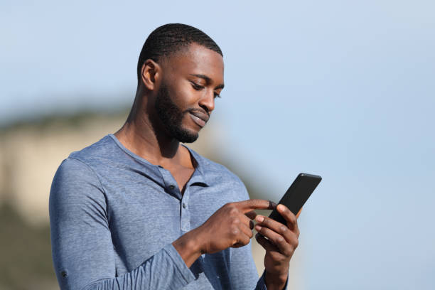 istock Man with black skin using smart phone in mountain 1362592878
