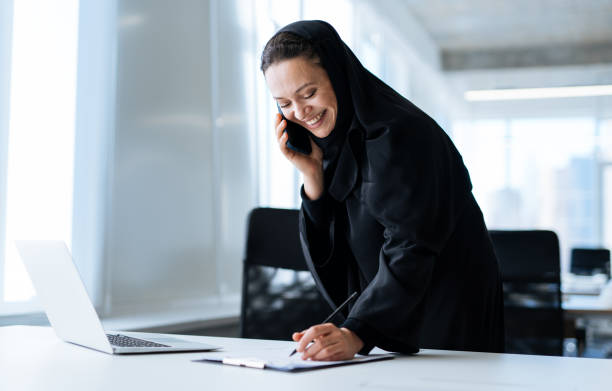 hermosa mujer árabe con vestido de abaya trabajando en la oficina - women islam middle eastern ethnicity arabic style fotografías e imágenes de stock