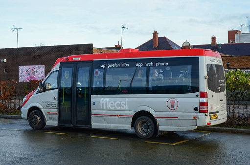 Prestatyn, UK: Dec 14, 2021: An accessible minibus parked at the bus station is being operated on behalf of TFW. It is operating a demand responsive local bus service called fflecsi.